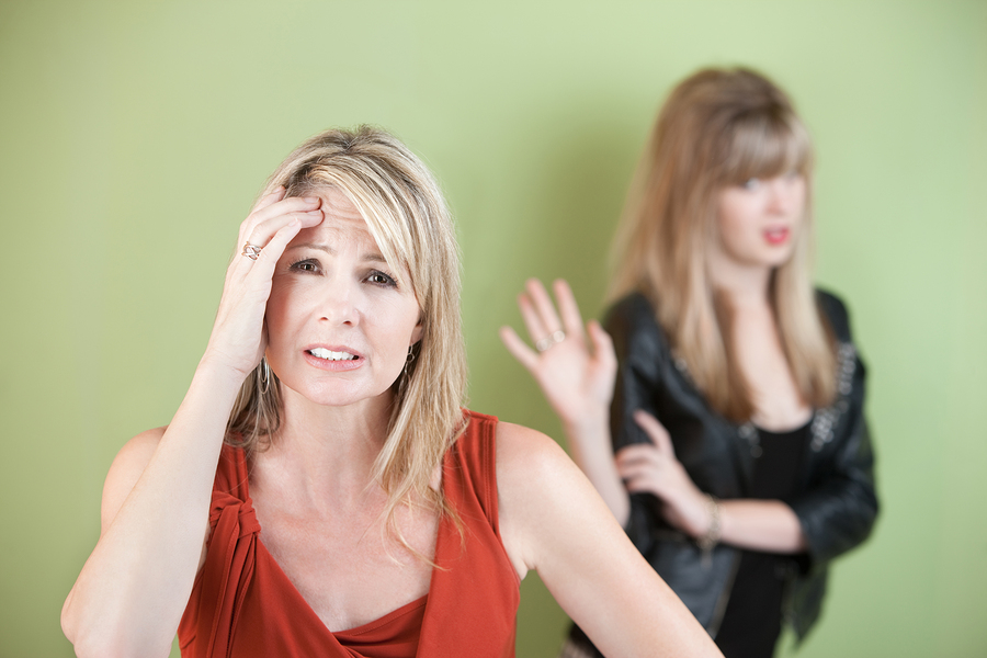 Upset mom with frustrated daughter over green background