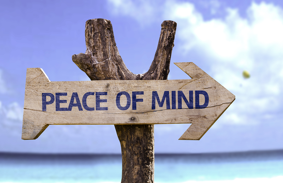 Peace of Mind wooden sign with a beach on background